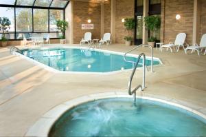 una gran piscina en un edificio con sillas y mesas en Drury Inn & Suites Cape Girardeau, en Cape Girardeau