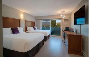 Habitación de hotel con 2 camas y TV en Coast Metro Vancouver Hotel, en Burnaby