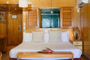 1 dormitorio con 1 cama con mesa y ventana en Sanctuary Rarotonga on the Beach (Adults Only), en Rarotonga