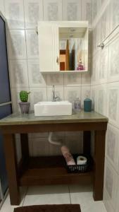 a bathroom counter with a sink and a mirror at Pousada Chalé Caminho da Guarda in Palhoça