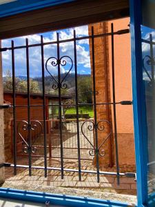 una puerta de hierro con vistas a las montañas a través de una ventana en Maison Sarraj en Compiano