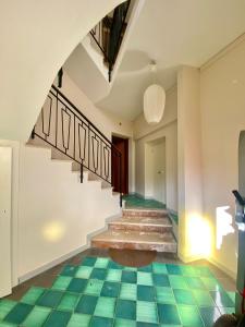 un pasillo con suelo de baldosa verde y escaleras en Maison Sarraj en Compiano
