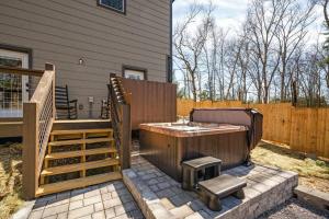 una bañera de hidromasaje en un patio junto a una casa en Tranquility/Mountain Cabin/Indoor Pool/Hot Tub/Games/Views, en Sevierville