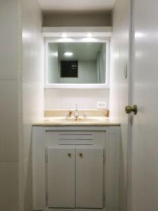 a white bathroom with a sink and a mirror at Apartamento Edificio Tuncahuan, 12 de octubre a 50mts Swissotel in Quito