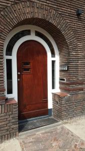 a wooden door on a brick building with an archway at LuxeLiving-Studio B in Eindhoven