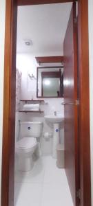 a bathroom with a toilet and a sink and a mirror at Hostal El Recreo in Barranquilla