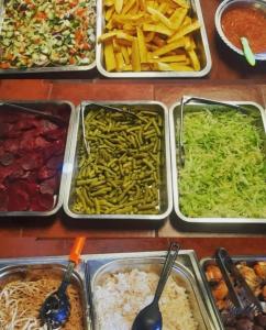 a table topped with trays of different types of food at Cabañas Campestres Villa Bella in Coroico Viejo