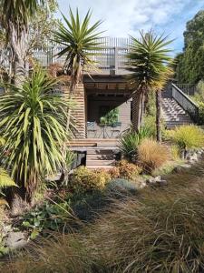 a bridge over a garden with palm trees at Mount Pleasant Views in Christchurch