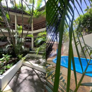 a resort with a swimming pool and palm trees at Pousada Casarão 2030 in Natal