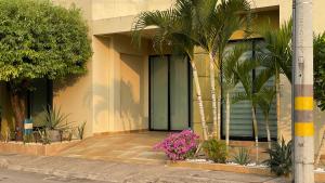 a building with palm trees and flowers in front of it at Casa en condominio in Flandes