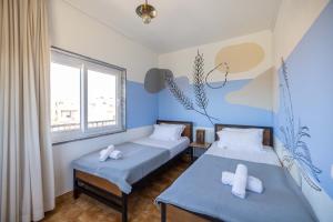 two beds in a room with blue walls at MUTE Hostel Milfontes in Vila Nova de Milfontes