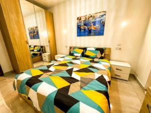 um quarto com um edredão colorido numa cama em Sliema Jacuzzi Flat em Sliema