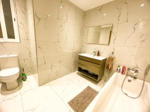 a bathroom with a tub and a toilet and a sink at Sliema Jacuzzi Flat in Sliema +25 photos
