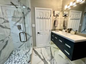 a bathroom with a shower and a sink and a glass door at Orchard Villa Disneyland 5 Bedroom Pool Home Spa in Anaheim