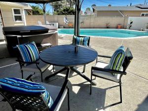 mesa y sillas con parrilla y piscina en Orchard Villa Disneyland 5 Bedroom Pool Home Spa en Anaheim