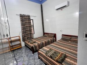 two beds in a room with a shower at Homestay view biển in Hoằng Lễ
