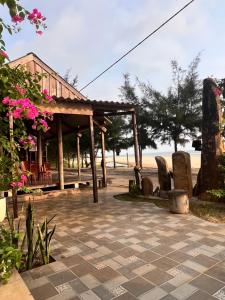 - un pavillon avec des chaises et des fleurs sur la terrasse dans l'établissement Homestay view biển, à Hoằng Lễ