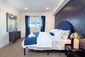a bedroom with a blue and white bed and a window at Timeless Glamour: Luxury Condo in K-Town in Los Angeles