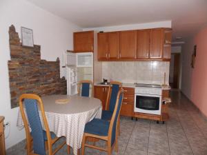 eine Küche mit einem Tisch und Stühlen sowie eine Küche mit einem Herd in der Unterkunft Otok Krk Apartments in Čižići