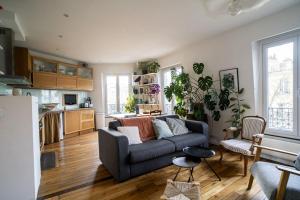 a living room with a couch and a kitchen at Nice Appartment near Buttes Chaumont in Paris