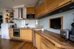 une cuisine avec des placards en bois et un comptoir en bois dans l'établissement Nice Appartment near Buttes Chaumont, à Paris