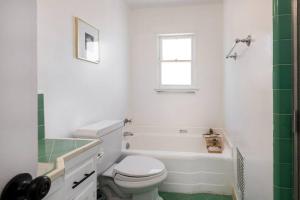 La salle de bains blanche est pourvue de toilettes et d'une baignoire. dans l'établissement Luxe 1-bedroom Apartment w/ Hot Tub, à Los Angeles