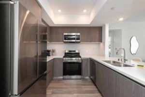 a kitchen with a stove and a sink at Deluxe Modern 2-bedroom Condo w/ Roof Deck! in Los Angeles