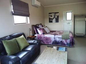 a living room with a couch and a bed at Chris and Dave's B & B in Otorohanga