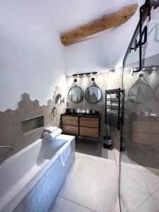 a bathroom with a sink and two mirrors at Hôtel d'Angleterre, Salon-de-Provence in Salon-de-Provence