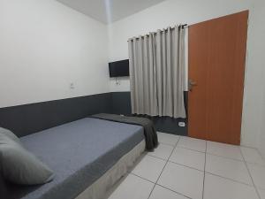 1 dormitorio con 1 cama y TV en Refugio Piratininga térreo 102, en Niterói