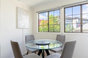 a dining room with a glass table and chairs at Bright & Cosy 1-Bed 15-Min From CBD in Brisbane