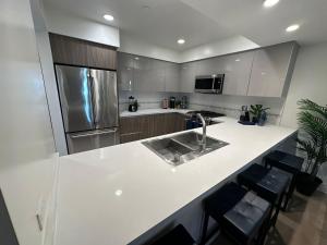 a kitchen with a white counter top and a refrigerator at The Century City Cozy 3 Bedroom Apartment with free parking! in Los Angeles