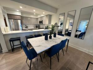 cocina y comedor con mesa y sillas azules en The Century City Cozy 3 Bedroom Apartment with free parking!, en Los Ángeles