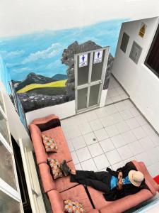 瓦拉斯的住宿－Sunrise Guest House，一位女士躺在地板上,在一间有画作的房间