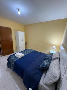 1 dormitorio con 1 cama con edredón azul en Departamentos Malargue en Malargüe