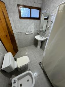 a bathroom with a toilet and a sink at Departamentos Malargue in Malargüe +1 photo
