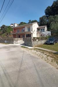 a house with a car parked on the side of a road at Apartments by the sea Supetarska Draga - Donja, Rab - 5042 in Supetarska Draga