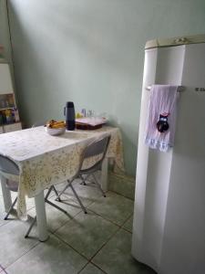 a kitchen with a table and a white refrigerator at Fazenda Santa Rita in Curvelo