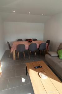a dining room with a table and chairs and a couch at Apartments by the sea Supetarska Draga - Donja, Rab - 5042 in Supetarska Draga