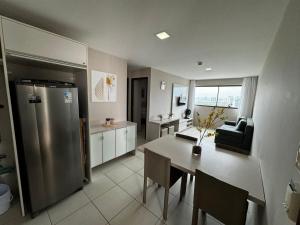 a kitchen and dining room with a stainless steel refrigerator at Hosts BR - Flat Beach Class Boa Viagem (sem taxas) in Recife