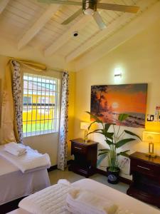 a bedroom with two beds and a painting on the wall at The Surada Bay in Old Harbour