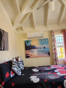 um quarto com uma cama com um quadro na parede em The Surada Bay em Old Harbour