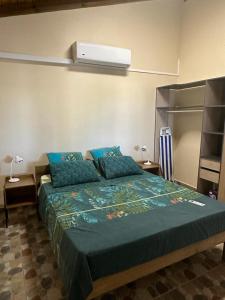 a bedroom with a bed with blue pillows at Dependance Sainte Marguerite in Le Moule