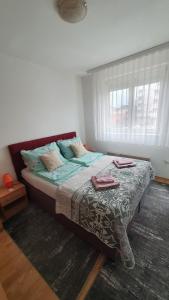 Un dormitorio con una cama grande con almohadas. en Apartman Dada, en Bijeljina