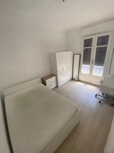 a white room with a bed and two windows at Central big apartament in Barcelona