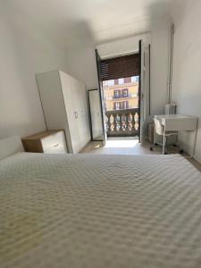 een slaapkamer met een bed, een bureau en een raam bij Central big apartament in Barcelona