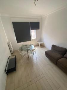 een woonkamer met een bank en een glazen tafel bij Central big apartament in Barcelona