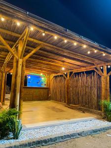 a wooden pergola with a tv in it at night at Hotel Alikaa Wayira in Ríohacha