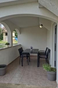 un tavolo nero e sedie su un patio di Apartments with a parking space Povljana, Pag - 224 a Povljana (Pogliana)