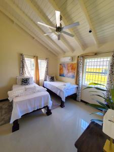a bedroom with two beds and a ceiling fan at The Surada Bay 2 bedrooms in Old Harbour